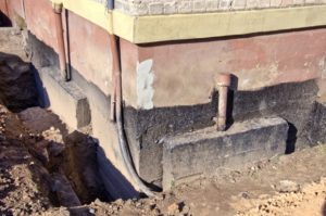 Open trench exposing the foundation of a building