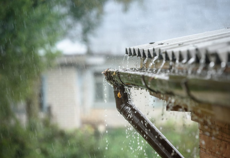 Heavy rain falling into gutters on home