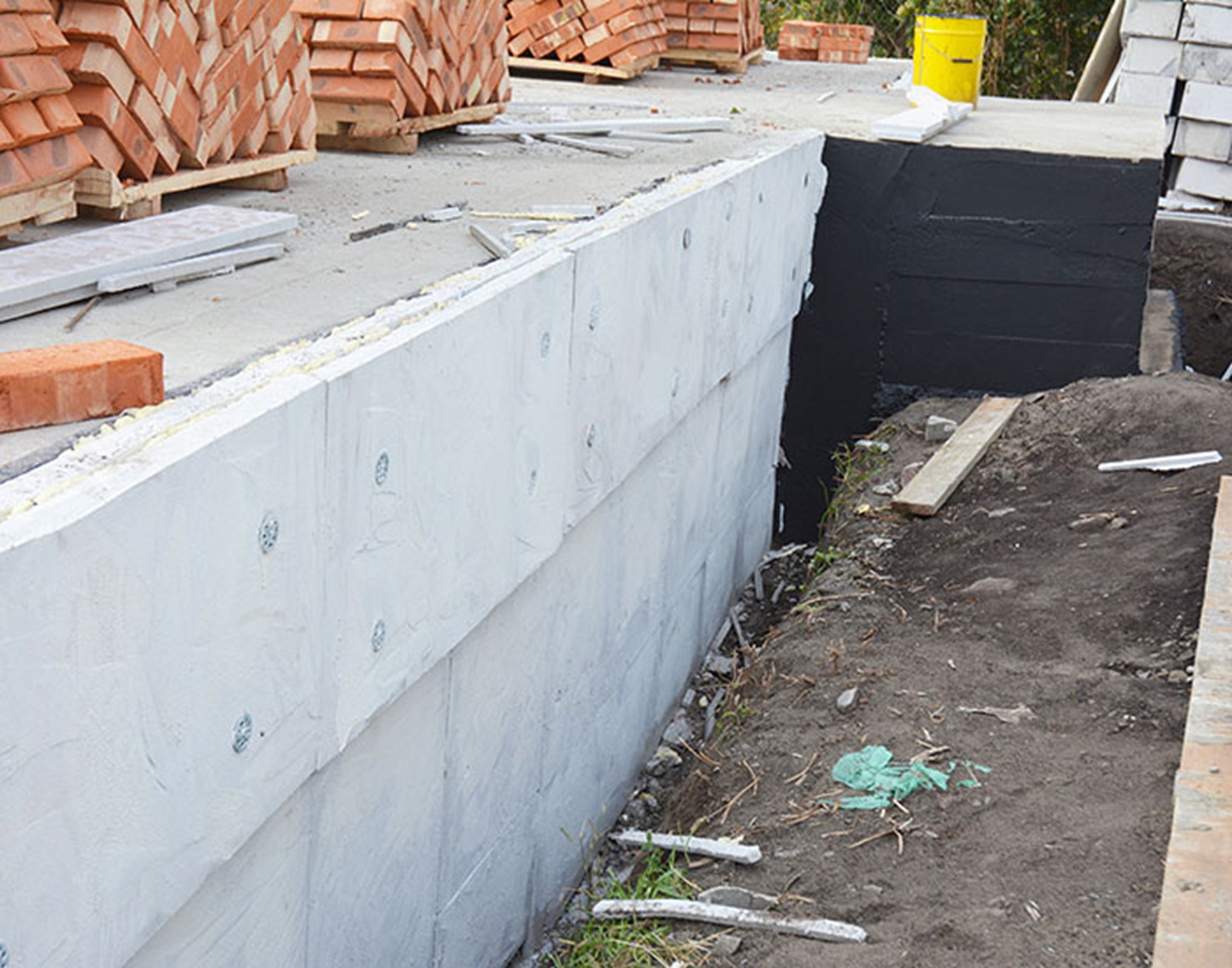 Coating being applied to the foundation of a home to provide basement waterproofing