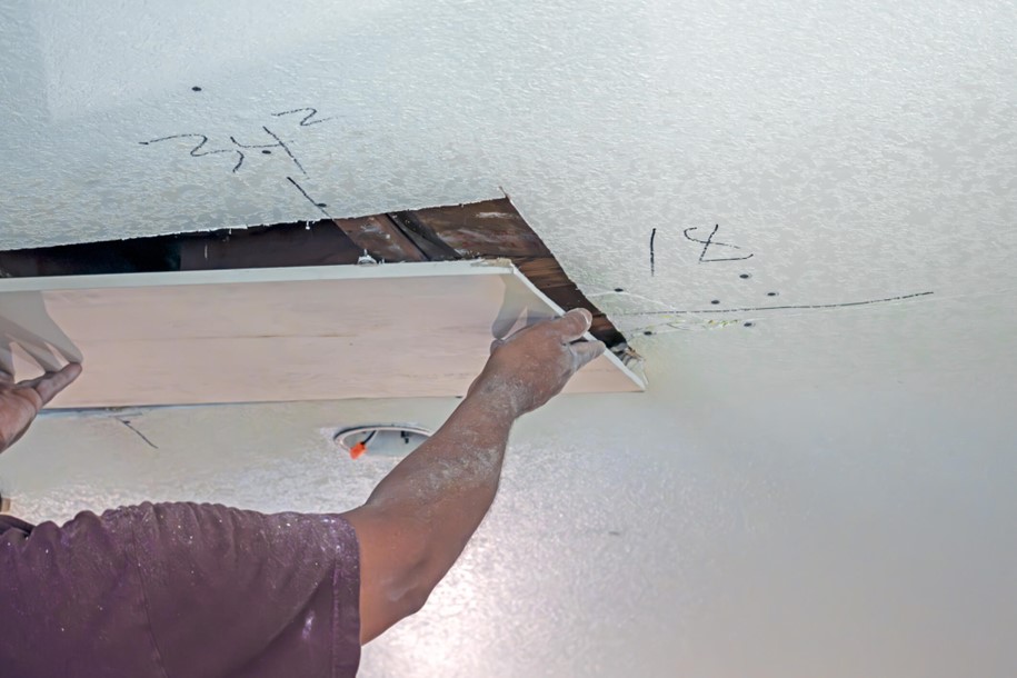 A person repairing drywall