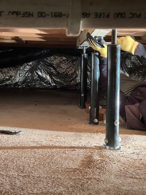 Floor joist support posts installed in crawlspace.